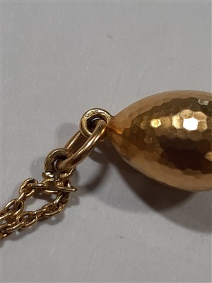 Lot 265 - A Russian yellow metal charm necklace, with two pendants and a locket by Fabergé