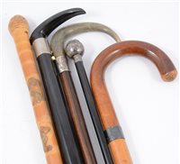 Lot 134 - A brass shell case stick-stand, with collection of sticks and a shooting stick.