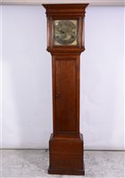 Lot 139 - Oak longcase clock, moulded cornice, plain frieze, the hood with three quarter turned columns, long door, plinth base, 11" square brass dial, with cast seraphim spandrels, chapter ring with Roman n...