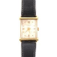 Lot 201 - Universal - a gentleman's Geneve wrist watch, rectangular 22mm x 20mm cream baton dial with centre seconds hand and quarter arabics in a yellow metal case marked on the back 18k 0.750, strap model