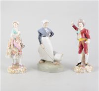 Lot 61 - A pair of continental figures depicting a man and a woman, 18.5cm tall and a Royal Copenhagen Goose Girl figure, 18.5cm tall. (3)