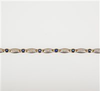 Lot 256 - A sapphire and diamond bracelet, eleven oval mixed cut sapphires spaced by ten groups of three brilliant cut diamonds in a yellow and white metal bracelet testing as 9 carat gold, 5mm wide
