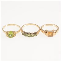 Lot 247 - Three stone set dress rings, a peridot five stone half hoop mount in all yellow metal marked 9K, ring size O, a peridot dress ring
