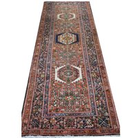 Lot 546 - Karajeh runner, seven medallions on a patterned red field, border within guards, 325cm x 110cm.