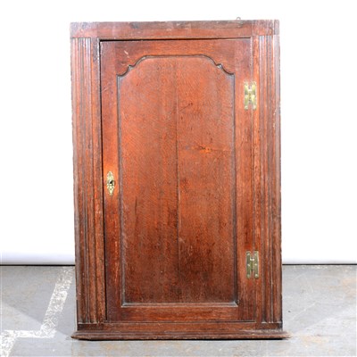 Lot 292 - George III oak hanging corner cupboard, arched panel door, three shelves, Height 110cm.
