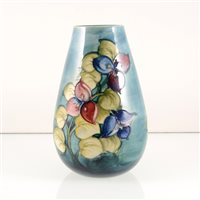 Lot 530 - A Moorcroft Pottery vase, designed by Walter Moorcroft, exotic flowers on a smokey blue ground.