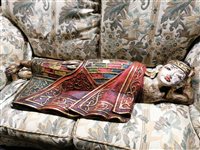 Lot 400 - Indian carved and painted figure, of a reclining deity, length 115cm.