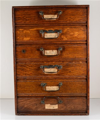 Lot 213 - A collectors cabinet by Henry Stone & Son, Banbury, 31cm x 45cm x 26cm, six drawers containing a quantity of uncut gemstone and polished fossilised material specimens