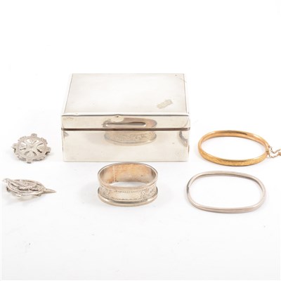Lot 240 - A silver cigarette box by William Comyns & Sons Ltd, cedar lined, London 1932, 19.2cm wide, 11.5cm long, 4.5cm high, containing a Scottish silver brooch, a silver napkin ring, two bangles etc.