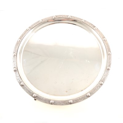Lot 200 - A silver salver, circular with raised Celtic design border, three dolphin feet, London 1934, 35.5cm diameter, weight approx. 39.5oz.