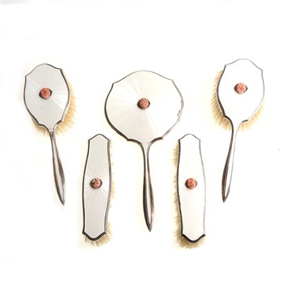 Lot 194 - A five piece silver and white enamel dressing table set by Asprey & Co Ltd, marcasite and coral-coloured centre decoration, Birmingham 1935, with jubilee hallmark.