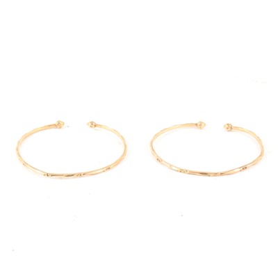 Lot 241 - A pair of yellow metal open ended torque bangles, marked "10K", 2.2mm width, total weight approx. 17.3gms.