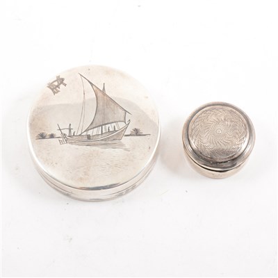 Lot 239 - A white metal patch box with mirror depicting a niello sailing junk, 50mm, and another 25mm pill box with engine turned cover, Birmingham 1918.