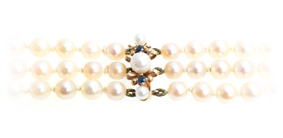 Lot 335 - A three row cultured pearl necklace with sapphire and pearl clasp.