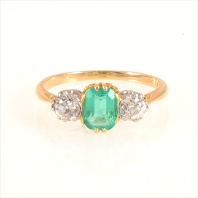 Lot 674 - An emerald and diamond three stone ring.