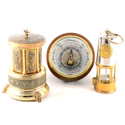 Lot 179 - A circular modern aneroid barometer, musical cigarette dispenser, and miner's lamp.