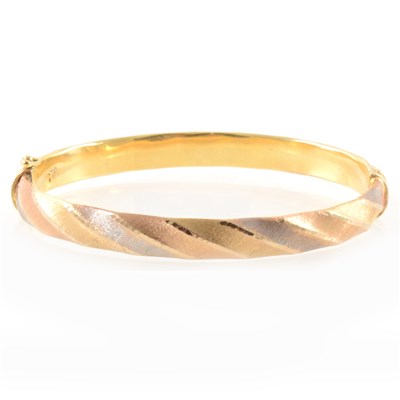 Lot 359 - A tri-colour half hinged bangle.