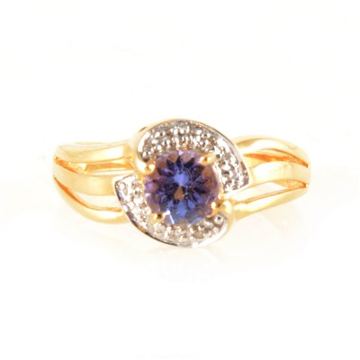 Lot 156 - A circular tanzanite and diamond crossover ring.
