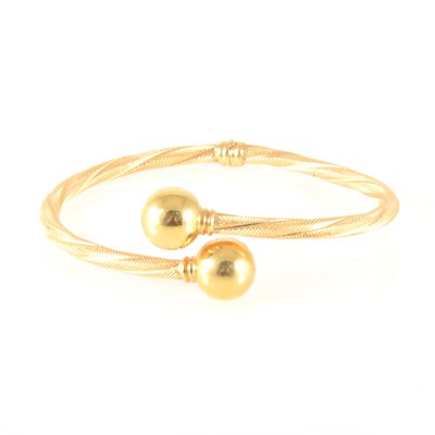 Lot 174 - An 18 carat yellow gold half hinged bangle.