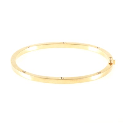 Lot 175 - An 18 carat yellow gold half hinged bangle.