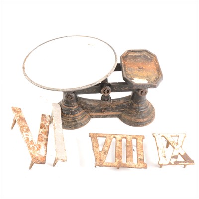 Lot 109 - A collection of cast iron clock golf markers, a set of cast iron balance scales, and wooden butter pats.