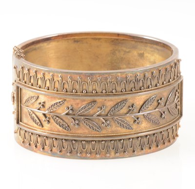 Lot 95 - A mid 19th Century yellow metal 33mm wide half hinged bangle