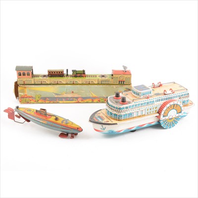 Lot 436 - Tin-plate toys; three including German clock-work train line with engine shed, boxed, a J187 HMS Nautilus submarine, 26cm, Modern Toys Japan toys Queen River steam boat, 35cm.