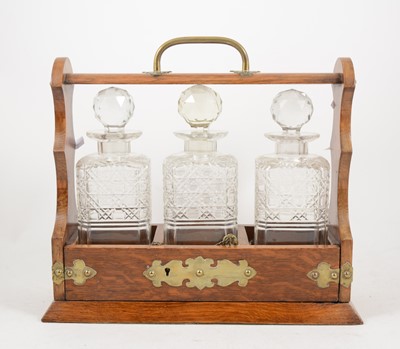 Lot 205 - An Edwardian oak three-bottle tantalus.