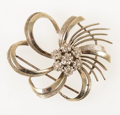 Lot 62 - A white metal diamond set swirl brooch.