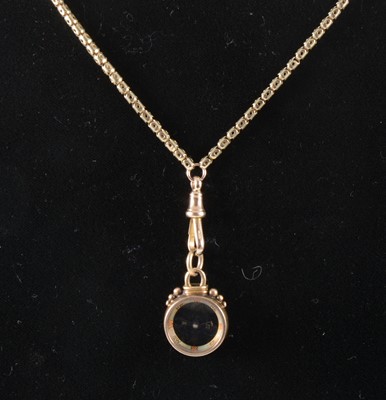 Lot 106 - A yellow metal short guard chain and compass fob.