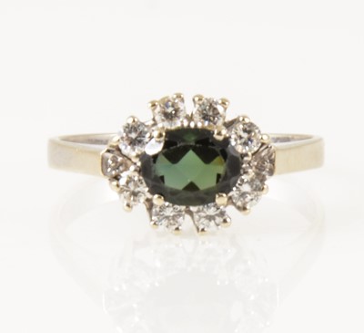 Lot 21 - A sapphire and diamond oval cluster ring.