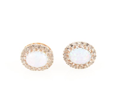 Lot 1232 - A pair of opal and diamond oval cluster earrings.