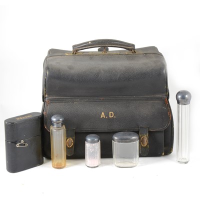 Lot 114 - Leather travelling bag with part fitted silver-mounted glass bottle set