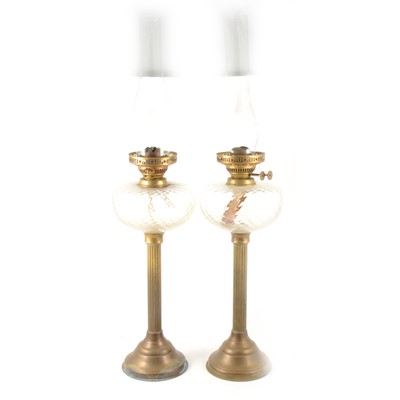 Lot 214 - Pair of brass oil lamps with clear glass reservoirs
