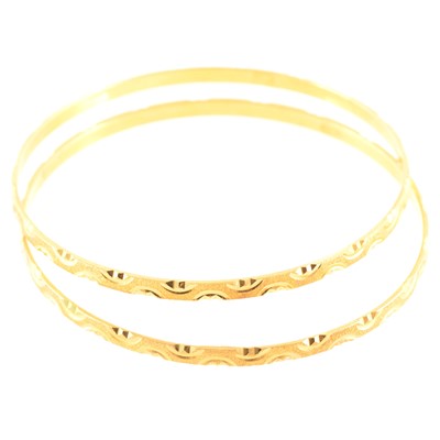 Lot 257 - Two yellow metal slave bangles.