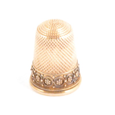 Lot 304 - A gilt metal thimble, filigree floral border, in fitted case.