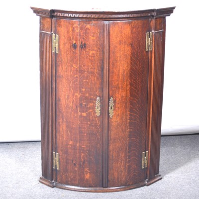 Lot 492 - George III oak bowfront hanging corner cupboard