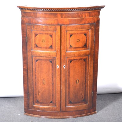 Lot 117 - George III oak and mahogany bowfront hanging corner cupboard
