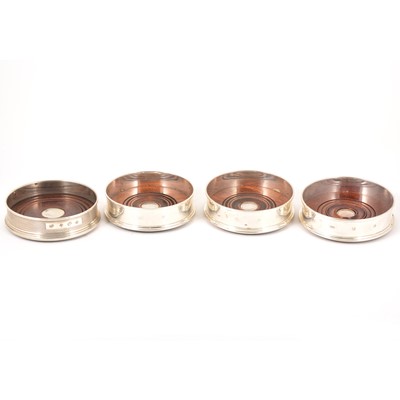 Lot 106 - A pair of silver hallmarked wine coasters, M C Hersey & Son Ltd, London 1995, and two others.