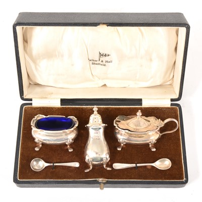 Lot 101 - A three-piece condiments set, Walker & Hall, Birmingham 1932, plus two silver salt spoons.