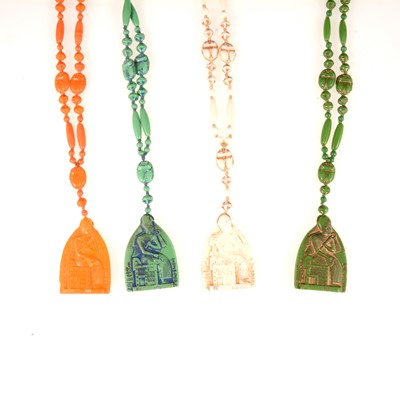 Lot 360 - Four Egyptian Revival pressed glass scarab bead sautoir necklaces.