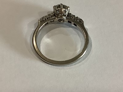 Lot 58 - A diamond solitaire ring with diamond shoulders.