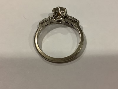 Lot 58 - A diamond solitaire ring with diamond shoulders.