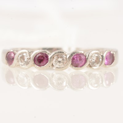 Lot 299 - A pltinum ruby and diamond half hoop ring.
