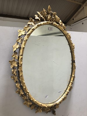 Lot 626 - An oval wall mirror, in a gilt gesso vine leaf surround