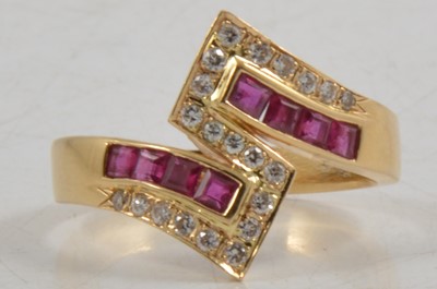 Lot 266 - A ruby and diamond crossover ring.