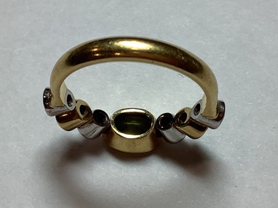 Lot 27 - A peridot and diamond half hoop ring.