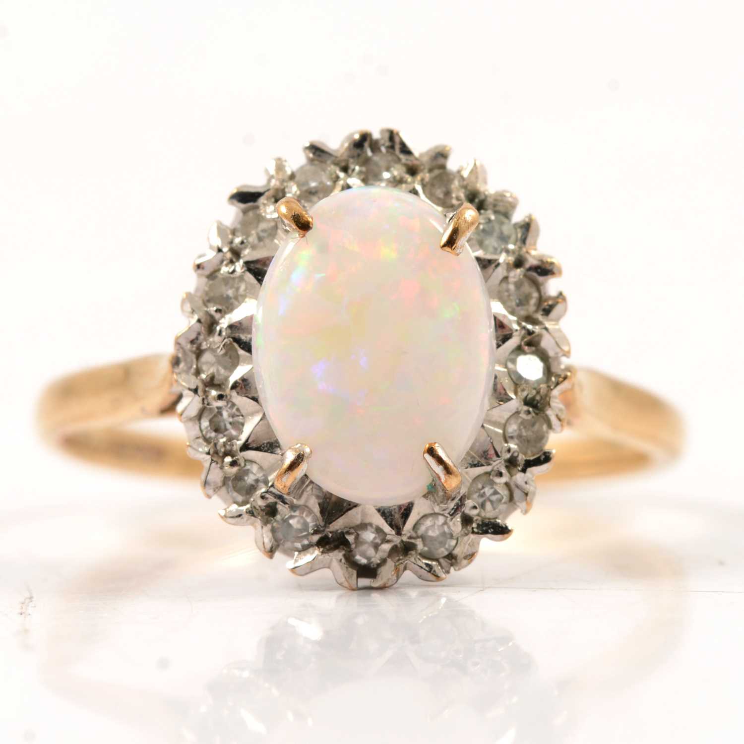 Lot 50 - An opal and diamond oval cluster ring.