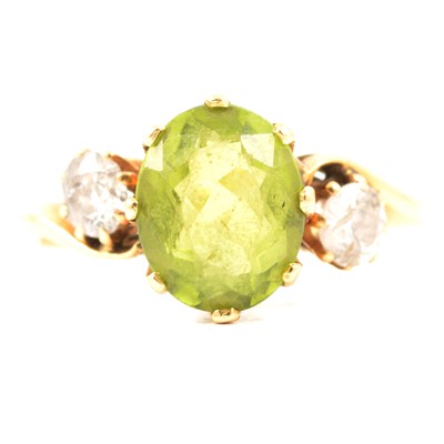 Lot 63 - A peridot and diamond three stone ring.