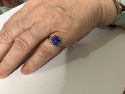 Lot 45 - A sapphire ring with two baguette cut diamonds in each shoulder.